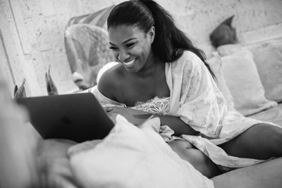 bride laughing with computer day of wedding