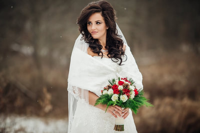 Bride posing in snow with bouquet