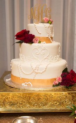 3 tier wedding cake with pearl icing and initial topper