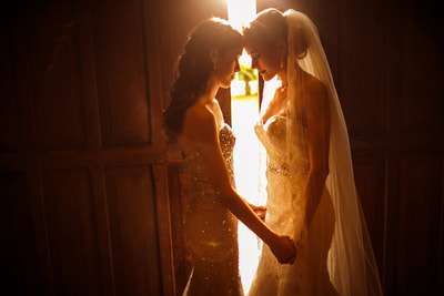 Bride and maid of honor holding hands head to head
