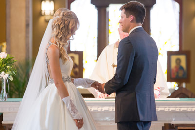Groom holding brides hand at the altar