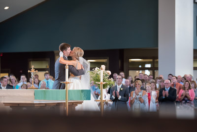 Newlyweds kissing at the altar