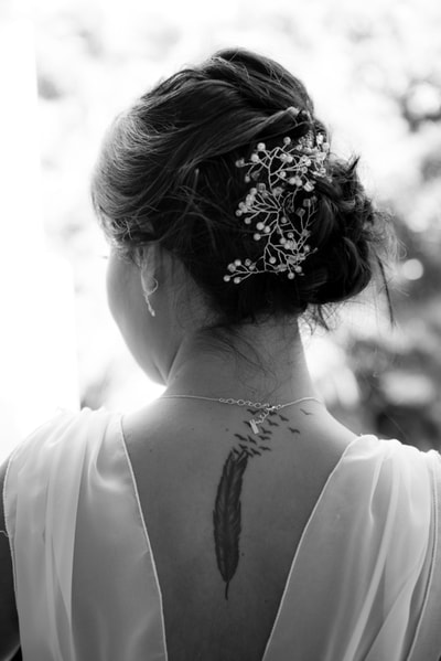 B&W feather tattoo on brides neck
