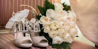 Bridal shoes next to white roses